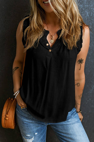 A person with long hair is wearing the Hemslee Button Split Neck Frilly Detail Tank Top in black from Little Daisy Closet, perfect for spring and summer wear, paired with distressed blue jeans and holding a woven bag. They have multiple tattoos on their arms and are accessorized with a necklace and bracelets. The background is a dark, textured surface.