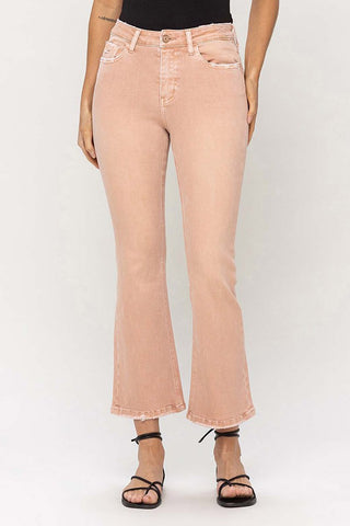 A person wearing the Carter Peach High Rise Kick Flare jeans from VERVET by Flying Monkey paired with black sandals featuring thin straps. The upper body is not visible in the image, and the background is plain white or light gray.