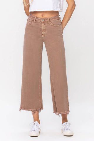 A person wearing the Roan High Rise Crop Wide Leg Jean by VERVET by Flying Monkey, paired with white sneakers and a cropped white top. The background is plain white.