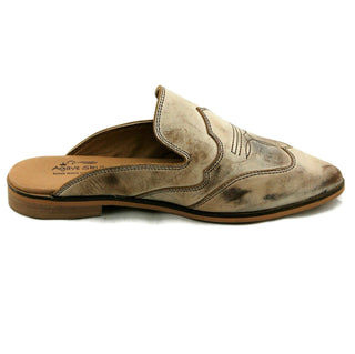 The Adaire Classica Western Mule by Western Edge Boutique is a beige slip-on with decorative stitching, featuring a low wooden heel, a slightly worn texture, and a cushioned leather insole for added comfort.
